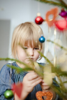 Mädchen schmückt Weihnachtsbaum - FOLF09118