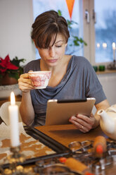 Frau benutzt digitales Tablet am heimischen Tisch - FOLF09128