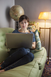 Frau mit Laptop auf Sofa - FOLF09130