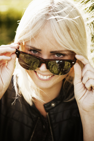 Lächelnde junge Frau mit Sonnenbrille, lizenzfreies Stockfoto