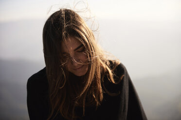 Close-up of woman against mountains during foggy weather - CAVF34232