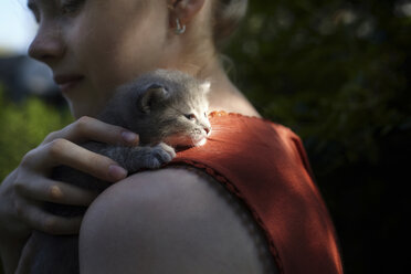 Side view of woman embracing cat - CAVF34291