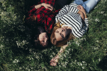 High angle view of female friends napping on grassy field - CAVF34322