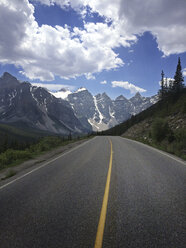 Asphalt road leading to snowcapped mountains - CAVF34386