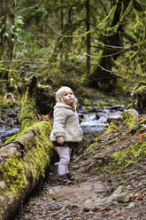 Cute girl looking up while standing in forest - CAVF34415