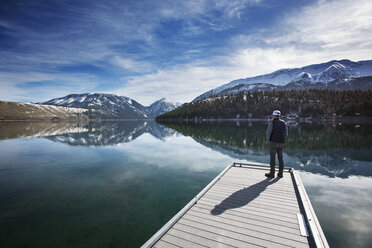 Rear view of man looking at Wallowa Mountains while standing on pier - CAVF34421