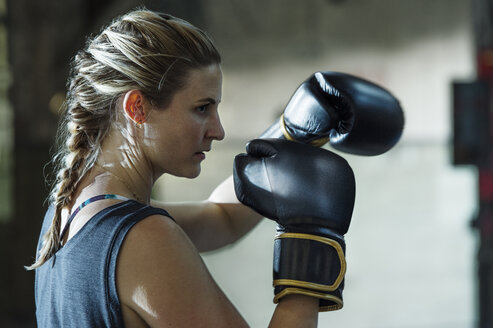 Seitenansicht eines selbstbewussten weiblichen Boxers im Fitnessstudio - CAVF34437