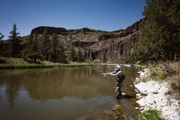 Seitenansicht eines reifen Mannes beim Fischen im Fluss am Berg - CAVF34443