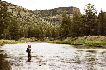 Seitenansicht eines reifen Mannes beim Fischen im Fluss am Berg - CAVF34446
