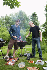 Männer im mittleren Erwachsenenalter beim Grillen im Hinterhof - FOLF09158