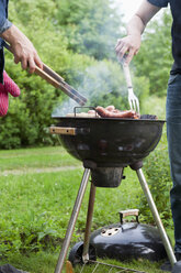 Männer im mittleren Erwachsenenalter beim Grillen im Hinterhof - FOLF09159