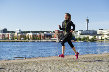 Junge Frau joggt am Wasser - FOLF09214