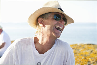 Portrait of smiling man wearing sunglasses and straw hat - FOLF09223