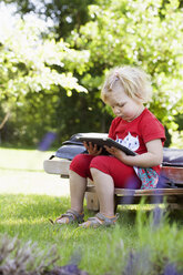 Girl sitting on deckchair with tablet pc - FOLF09298