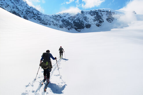 Ein Paar Menschen beim Telemark-Skifahren in einer Berglandschaft in Norwegen - FOLF09343
