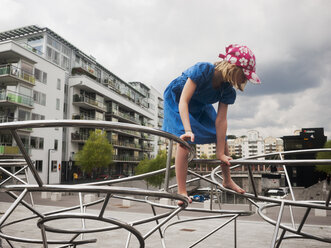 Mädchen klettert auf Metallinstallation - FOLF09354