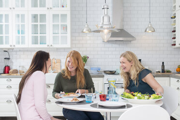 Three laughing women at kitchen table - FOLF09360