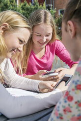 Mädchen im Teenageralter schreiben SMS mit dem Handy - FOLF09396