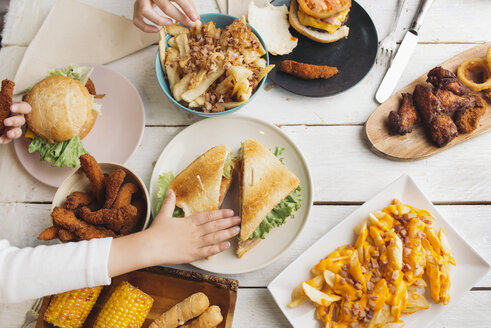 Kinderhände auf einem Tisch voller amerikanischer Lebensmittel - SKCF00391