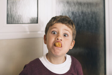 Porträt eines Jungen mit Essen im Mund, der Gesichter zieht - SKCF00395