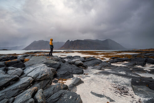 Norway, Lofoten Islands, Gimsoysand, man standing at rocky coast - WVF00928