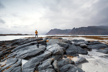Norway, Lofoten Islands, Gimsoysand, man standing at rocky coast - WVF00929