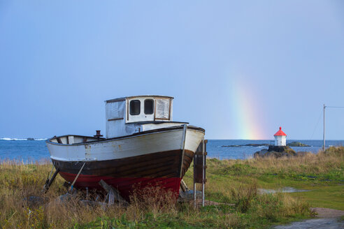 Norwegen, Lofoten Inseln, Eggum, Schiff an der Küste und Regenbogen über dem Meer - WVF00935