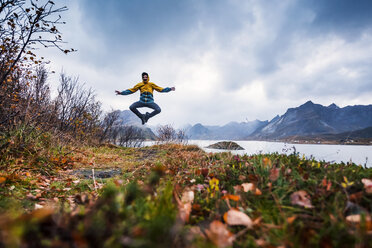 Norway, Lofoten Islands, man jumping at the coast - WVF00959