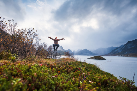 Norway, Lofoten Islands, man jumping at the coast stock photo