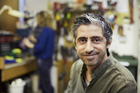 Porträt eines lächelnden reifen männlichen Freiwilligen bei einem Workshop, lizenzfreies Stockfoto