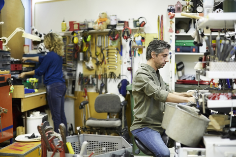 Mature volunteers working at workshop stock photo