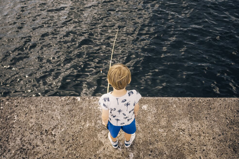 Hoher Blickwinkel auf einen Jungen, der am Pier steht und im Meer fischt - MASF00133