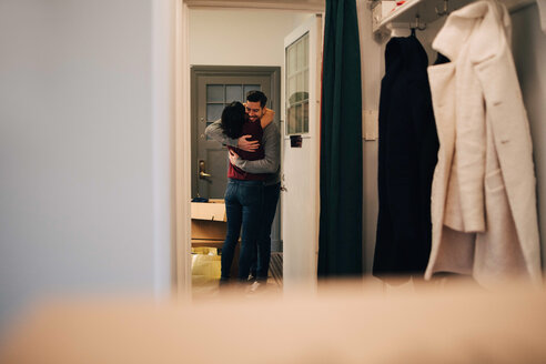 Paar, das sich umarmt, gesehen vom Eingang einer neuen Wohnung - MASF00204