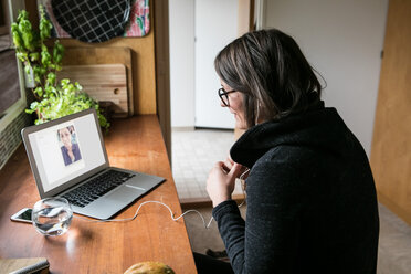 Side view of businesswoman video calling female colleague on laptop in home office - MASF00222