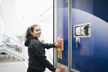 Lächelnde Frau drückt Knöpfe am Lieferwagen - MASF00280