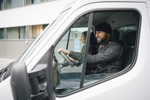 Männliche und weibliche Arbeiter sitzen in einem Lieferwagen in der Stadt - MASF00283