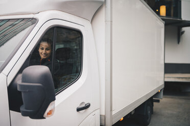 Lächelnde Arbeitnehmerin fährt weißen Lieferwagen in der Stadt - MASF00284