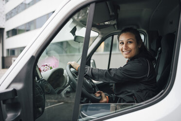 Porträt einer lächelnden Frau, die einen Lieferwagen in der Stadt fährt - MASF00285