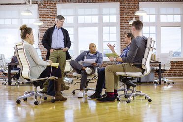 Business people planning while sitting on chairs in office - CAVF34465