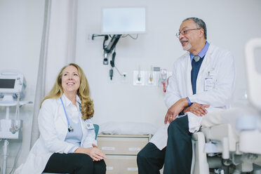 Ärzte im Gespräch, während sie in der Krankenstation sitzen - CAVF34509