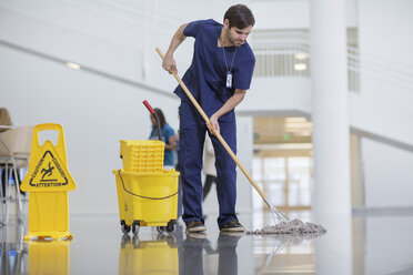 Male worker cleaning hospital floor - CAVF34528