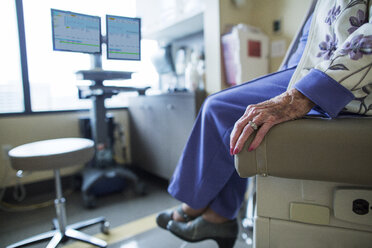 Niedriger Ausschnitt einer Patientin, die auf einem Bett in einer Krankenstation sitzt - CAVF34554