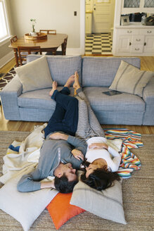 Blick von oben auf ein Paar, das sich zu Hause auf einem Teppich entspannt - CAVF34589