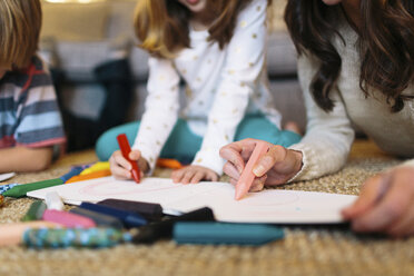 Mittelteil einer Mutter, die mit ihren Kindern zu Hause zeichnet - CAVF34601