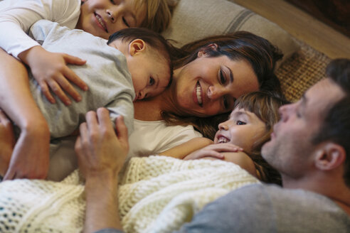 Hochformatige Ansicht von Kindern mit Eltern, die zu Hause auf dem Teppich schlafen - CAVF34612