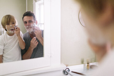 Father and son shaving while reflecting in mirror - CAVF34621