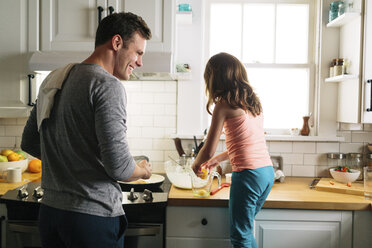 Glücklicher Vater und Tochter bereiten Essen in der Küche zu Hause vor - CAVF34626