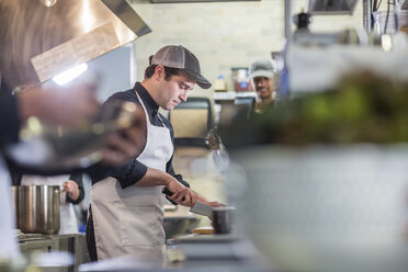 Männliche Köche arbeiten in der Restaurantküche - CAVF34692