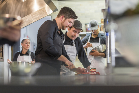 Köche bei der Zubereitung von Speisen in der Restaurantküche, lizenzfreies Stockfoto