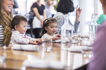 Familie sitzt am Tisch im Restaurant - CAVF34713